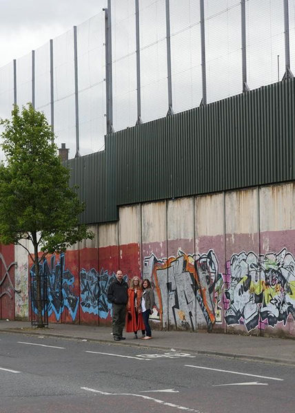 Formateur TechCamp, Michael McCabe, se tient près d’un « mur de la paix » à Belfast qui divise les quartiers catholiques et protestants. Photo de Christophe Neu.