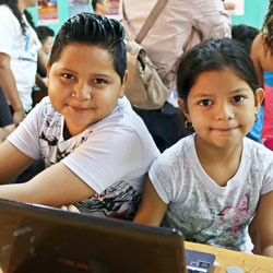 Salvadoran children coding in classroom.