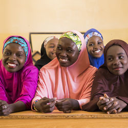 Nigerian girls smiling in classroom.