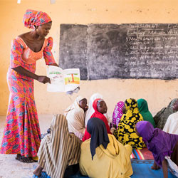 Teacher with children in Nigerian classroom.
