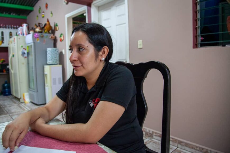 Orphan Helpers counselor Regina Luna talks with a young family in their home.