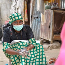 A volunteer wearing a mask gives a demonstration of hand washing in Northern Nigeria.