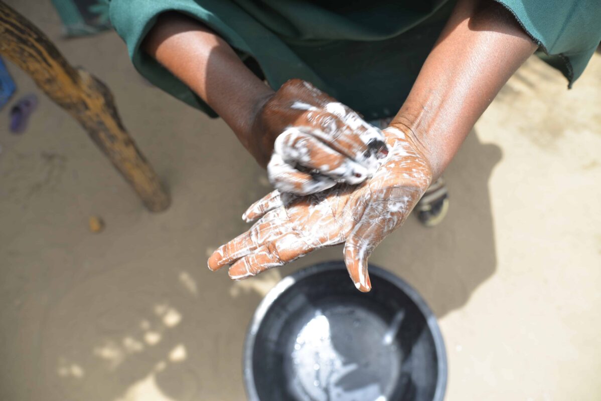 A woman demonstrates proper handwashing in Nigeria.