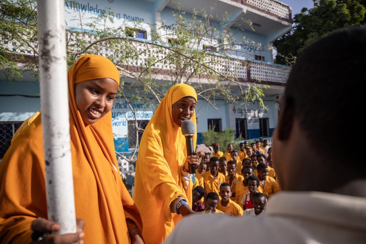 Une fille avec un microphone participe à un événement parascolaire dans son école.